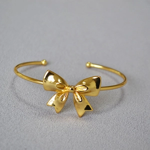 Polished gold-plated bow cuff bangle bracelet for women with minimalist open design