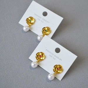 Detailed shot of gold flower earrings with pearls and S925 silver needles
