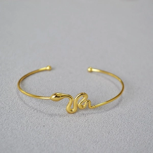 Minimalist gold-plated brass snake-shaped open adjustable bangle with black eyes detail