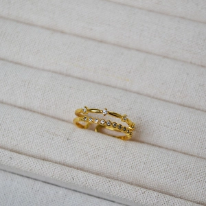 Close-up of double-layer brass ring with cubic zirconia micro-pave setting on display tray