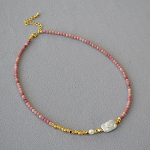 Detail of beaded necklace with pink natural stones, baroque pearls and gold lobster clasp