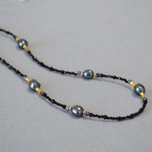 Detailed shot of handmade baroque pearl necklace with black spinel and gold spacer beads