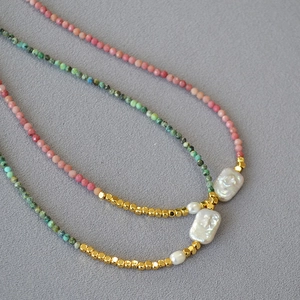 Detail of baroque pearl necklace with turquoise and mineral beads in a layered layout
