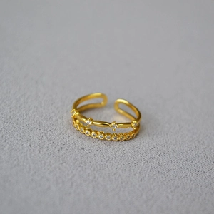 Macro shot of double-layer gold brass ring featuring cubic zirconia pavé and open band