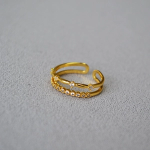 Macro view of double-layered brass ring with star-shaped and round-cut cubic zirconia stones