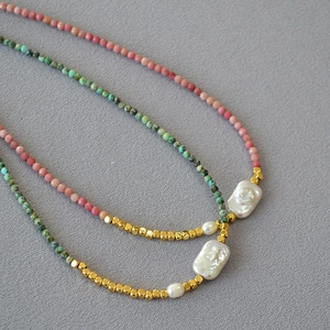 Detail of turquoise beads and baroque pearls on handmade jewelry with gold accents