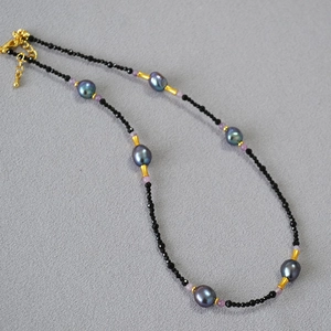 Detailed shot of baroque pearls with black spinel beads and golden bamboo spacers