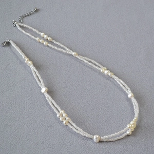 Detail of double-layered necklace with irregular baroque pearls and white seed beads