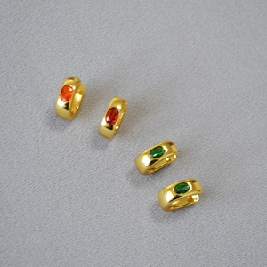 Detail of four gold-plated oval gemstone earrings in various vibrant colors