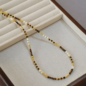 Collana di perle occhio di tigre e madreperla in una scatola di velluto grigio