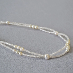 Detail of double-layer necklace with irregular baroque pearls and white seed beads