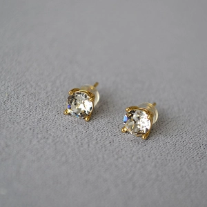 Macro shot of 925 silver gold-plated stud earrings with sparkling round-cut crystals
