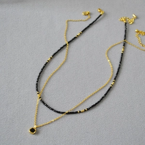Vue à plat du collier double rang avec pendentif carré en spinelle noir et chaîne perlée