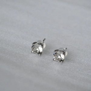 Close-up of brilliant-cut crystal stud earrings with silver 925 posts and silicone backs