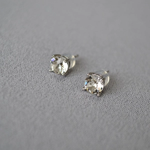 Macro view of sterling silver stud earrings with clear round cut stones and claw setting
