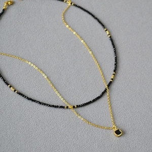 Collier double rang doré avec perles noires facettées et pendentif carré style onyx