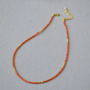 Detailed macro of orange faceted beads and golden metal spacers with lobster clasp
