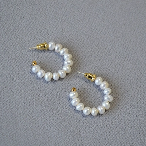 Vue détaillée des boucles d'oreilles en forme de C avec perles d'eau douce et clous dorés
