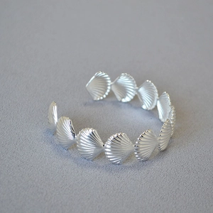 Polished silver seashell cuff bracelet with a vintage ocean-inspired shell link design