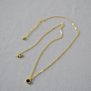 Collier double couche doré minimaliste avec un petit pendentif carré en spinelle noire