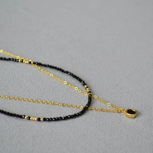 Vue détaillée du collier à deux rangs avec pendentif carré en spinelle noir et perles