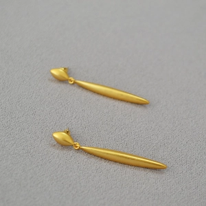 Macro view of French vintage style geometric matte gold teardrop earrings for women