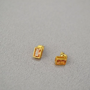 Close-up of golden rectangle earrings with amber crystal stones and 925 silver pins