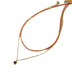 Double-layer necklace with orange beads and a square red gemstone pendant on gold chain