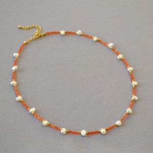 Beaded necklace with freshwater pearls, orange agate beads, and golden lobster clasp