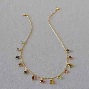 Detail of gold-plated necklace with colorful multi-shaped zircon pendants and lobster clasp