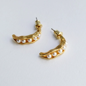 Detail of pea pod drop earrings with golden hammered brass and white pearls