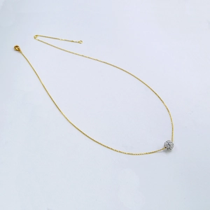 Détail du collier minimaliste en laiton doré avec pendentif boule de cristal étincelant
