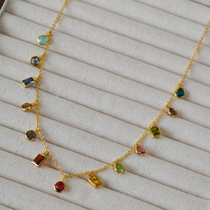 Macro view of a gold-plated rainbow necklace with colorful multi-shape zircon stones