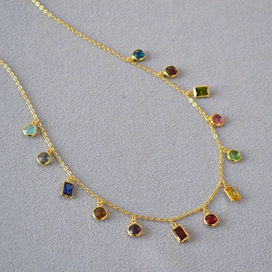 Detailed view of gold plated brass necklace with vibrant multicolored zircon gemstones