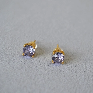 Detail of lavender crystal stud earrings with gold plating and four-prong setting