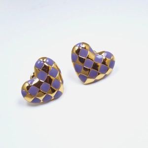 Close-up of heart stud earrings with purple and gold checkered enamel pattern