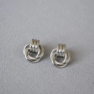 Detailed view of silver twisted multi-ring knot earrings with polished mirror finish
