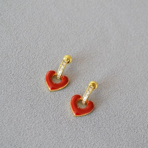 Detail of red heart enamel earrings with gold plating and cubic zirconia accents