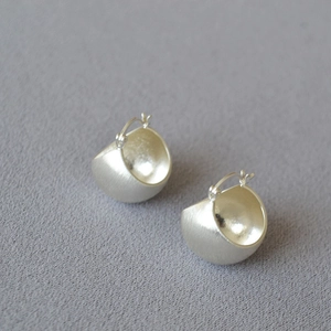 Minimalist brushed silver dome earrings featuring matte exterior and polished inner surface