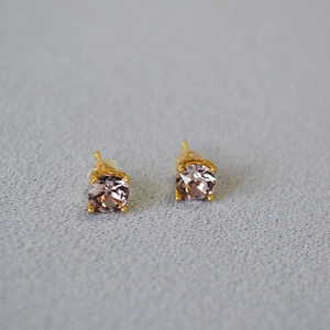 Macro shot of champagne crystal stud earrings with gold plating and four-prong setting