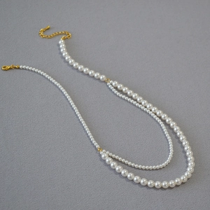 Close-up of double-layer white pearl necklace with golden lobster clasp and extender