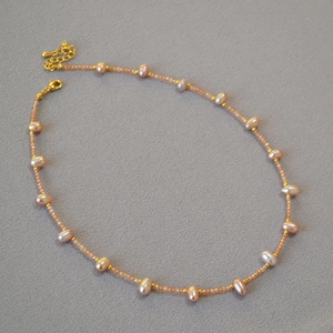 Macro shot of freshwater pearls and pink faceted beads necklace with gold clasp