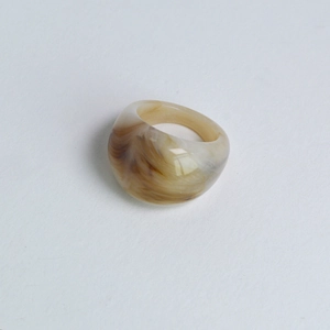 Vue de près d'une bague large en laiton avec texture résine marbrée et finition écaille