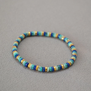 Bohemian elastic beaded bracelet with turquoise and gold discs in a minimalist style