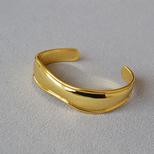 Polished gold-plated wide cuff bracelet with minimalist irregular open design