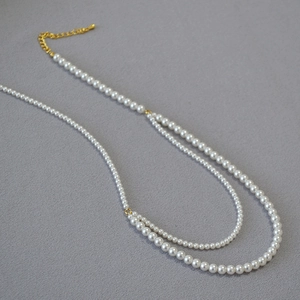 Close-up of double-layer faux pearl necklace with adjustable gold clasp and extender