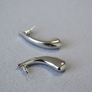 Minimalist silver mirror teardrop earrings in polished hollow brass on grey fabric background