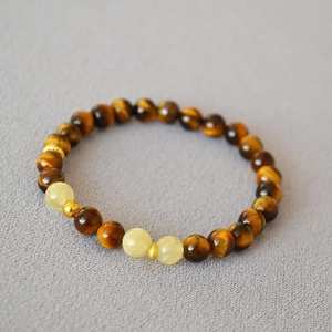 Bracelet en pierre naturelle oeil de tigre avec perles jaunes sur fond en tissu gris