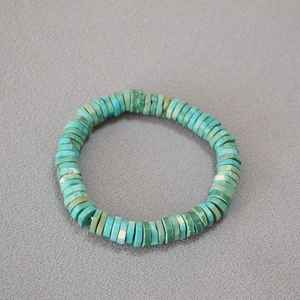 Close-up of bohemian turquoise heishi beaded elastic bracelet with stone textures