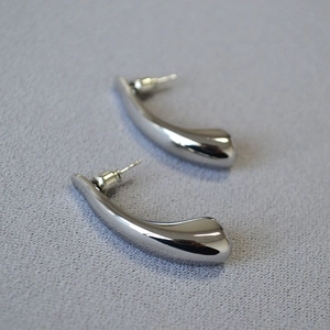 Close-up of polished silver teardrop earrings with smooth metallic finish and backings
